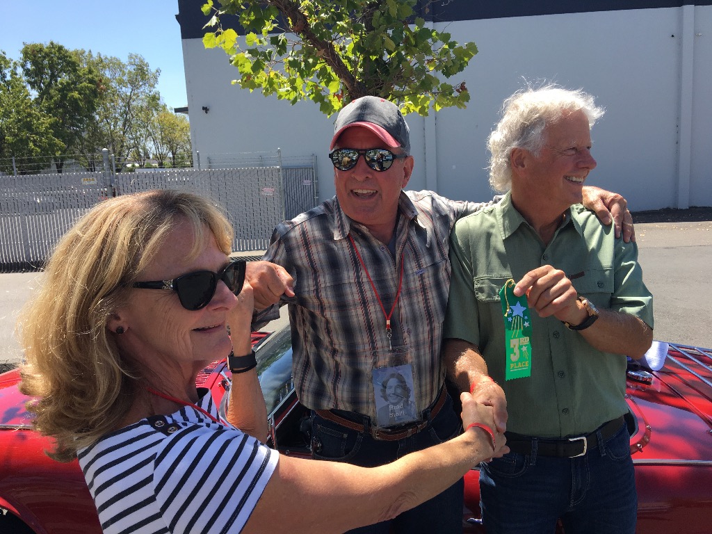 Joan Coates presenting 3rd place ribbon to Brad Stolfi and Doug Wagner in the back to the future car rally. Loved Bradâ